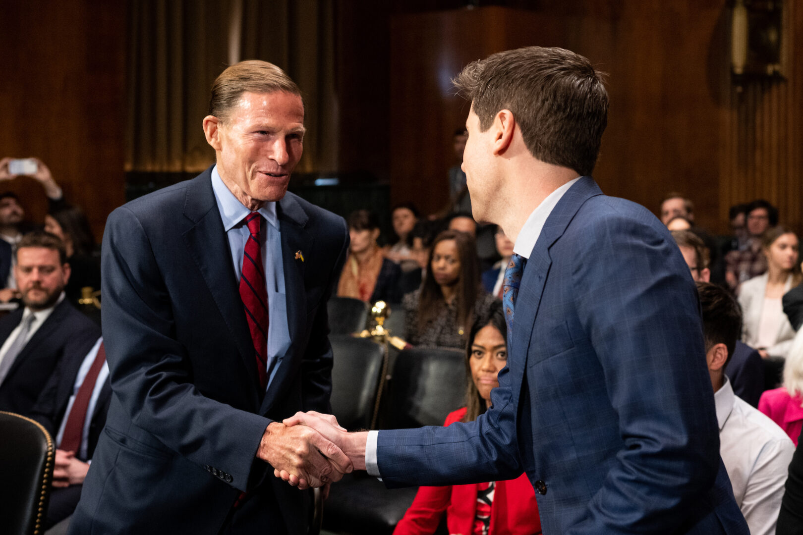 Sam Altman, CEO of OpenAI, right, shakes hands with Sen. Richard Blumenthal, D-Conn., before a Senate Judiciary subcommittee hearing on artificial intelligence oversight last year. Blumenthal is one of several senators sponsoring bills to limit the use of AI in political ads.