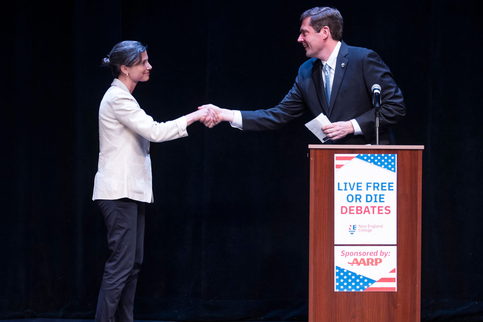 Democratic congressional candidates Maggie Goodlander, left, and Colin Van Ostern shake hands after the Live Free or Die Debates at the Rosamond Page Putnam Center for the Performing Arts on the campus of New England College in Henniker, N.H. on Sept. 4. (Geoff Forester/The Concord Monitor via AP)