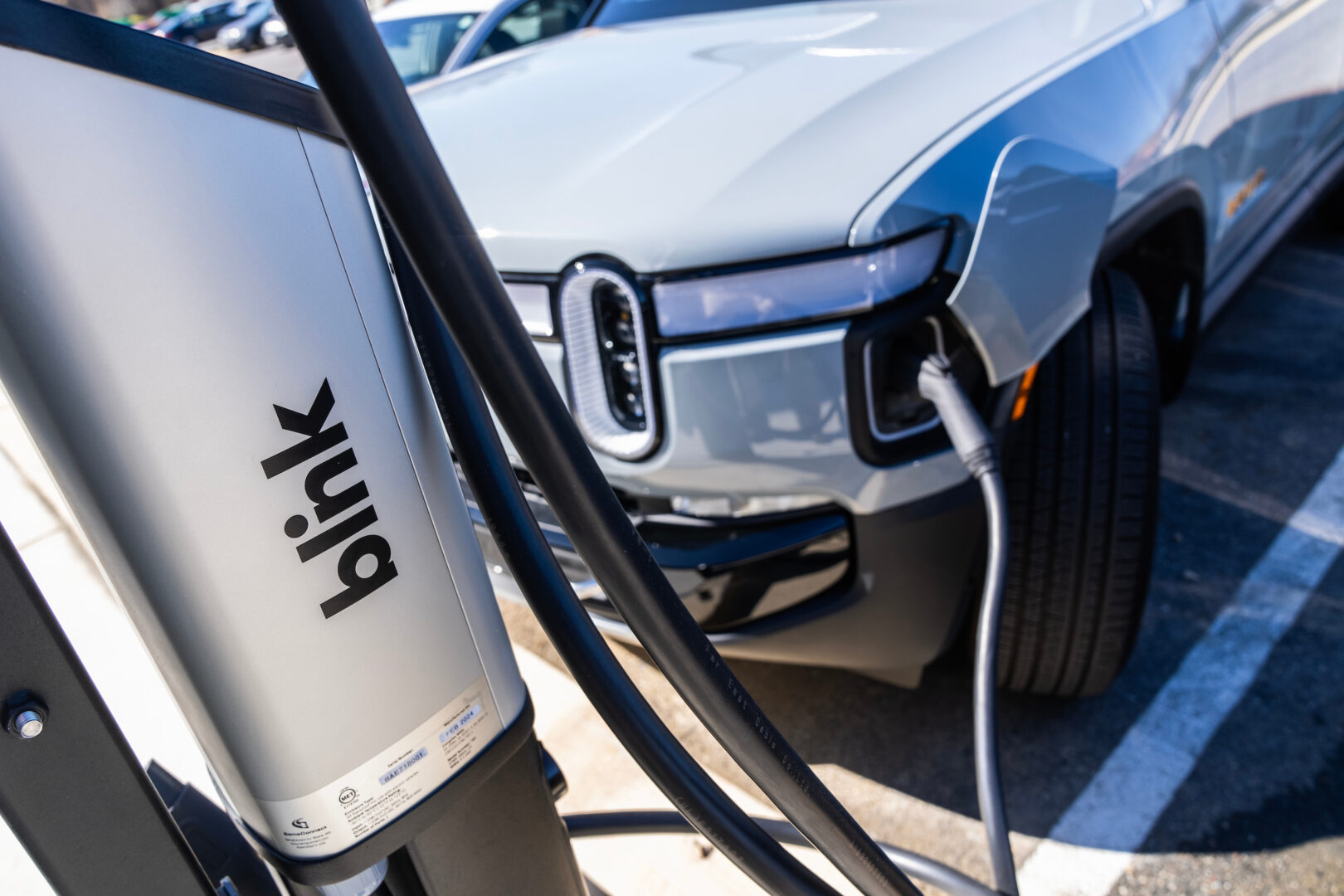 A Rivian electric vehicle charges outside of Blink Charging’s new flagship manufacturing facility in Bowie, Md., in March.