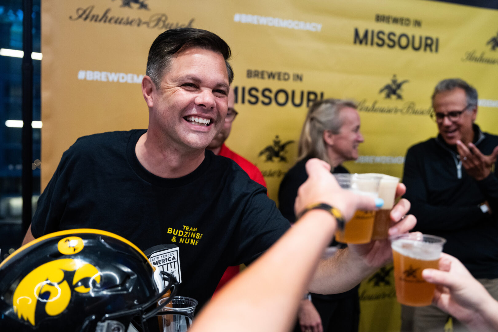 Rep. Zach Nunn, R-Iowa, and his teammate, Rep. Nikki Budzinski, D-Ill., center, serve up their concoction at Anheuser-Busch’s Congressional Brewing Competition at Nationals Park on Wednesday night.