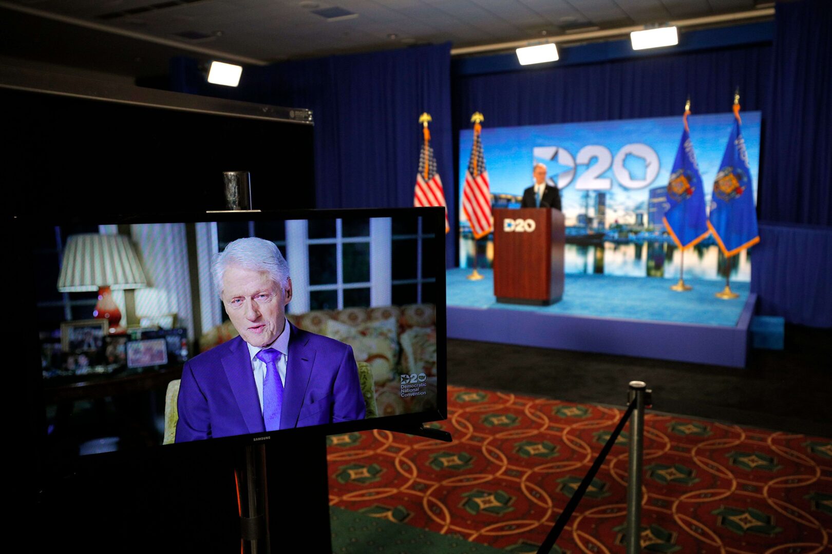 Former President Bill Clinton delivers a speech by video feed as Democratic National Committee Chairman Tom Perez watches from the podium in Milwaukee on Tuesday during the Democratic National Convention, being held virtually amid the coronavirus pandemic.