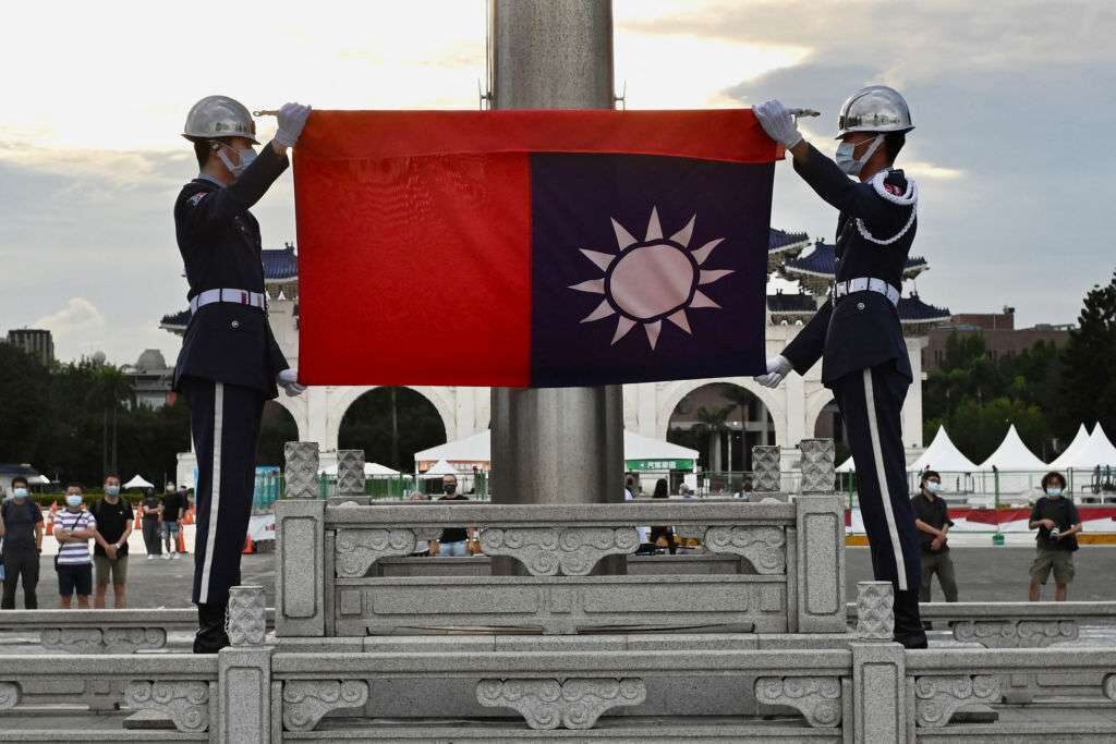 Honor guards fold the Taiwan flag during a ceremony at the Chiang Kai-shek Memorial Hall in Taipei on June 4.