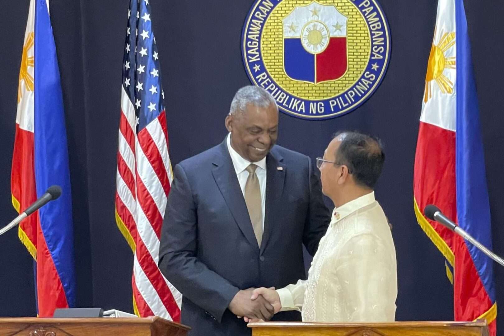 Defense Secretary Lloyd J. Austin III shakes hands with his Philippine counterpart, Carlito Galvez Jr., at a joint press conference in Camp Aguinaldo military headquarters in Manila on Feb. 2.