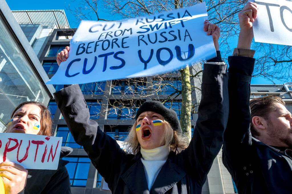 A protester in Belgium demands Russia be denied access to the SWIFT financial messaging system.