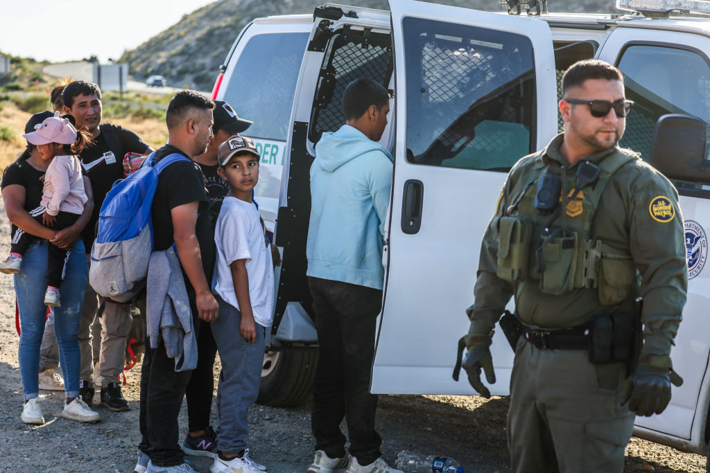 Families board a U.S. Customs and Border Protection vehicle at a makeshift camp in Jacumba Hot Springs, Calif.