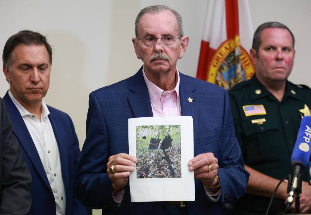 Palm Beach County Sheriff Ric Bradshaw holds a photograph of the rifle and other items found near where a suspect was discovered, during a press conference Sunday regarding an apparent assassination attempt of former President Donald Trump in West Palm Beach, Fla.