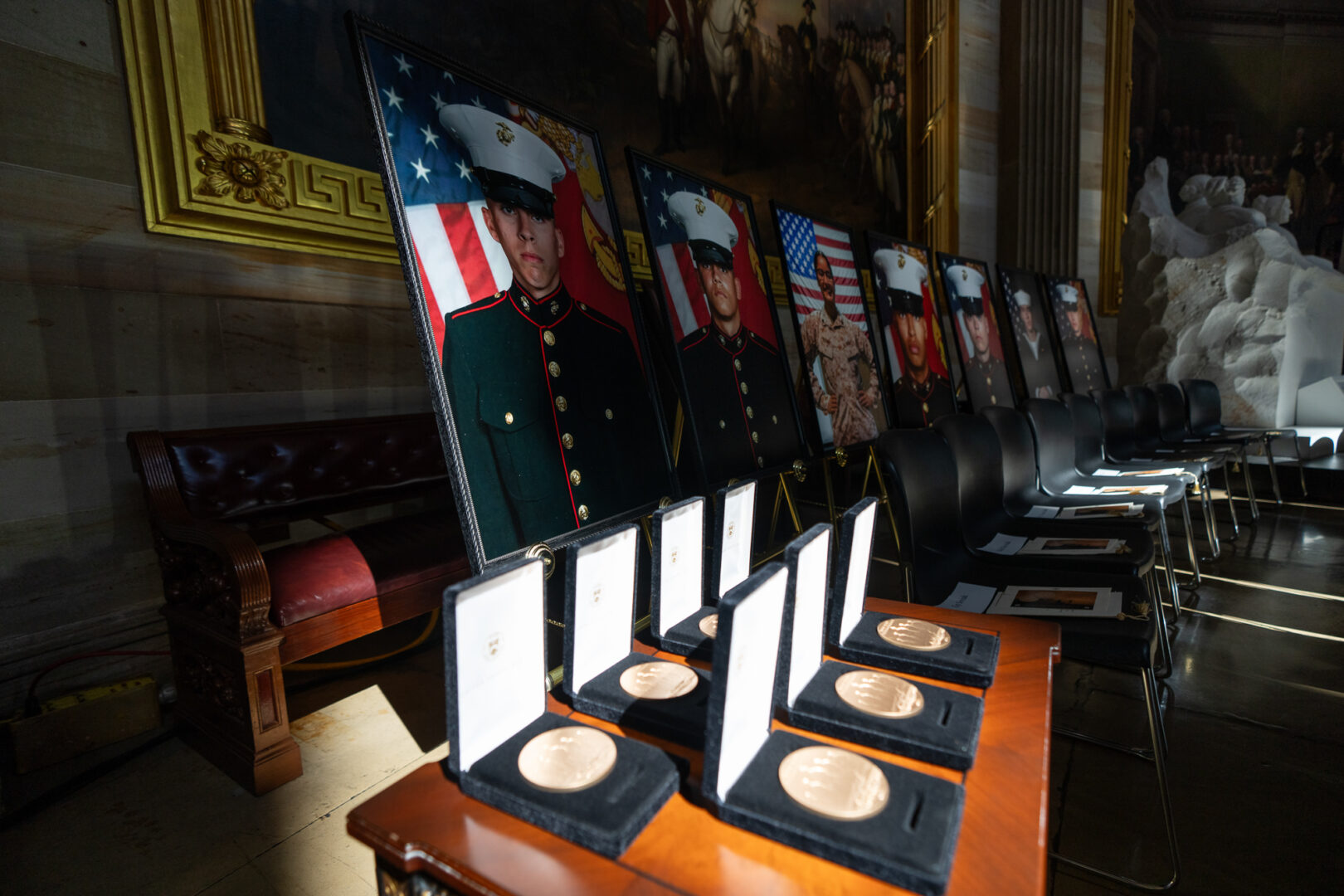 Congressional Gold Medals sit in front of photos of military servicemembers killed in the 2021 terrorist attack at the airport in Kabul, Afghanistan, before the start of the medal ceremony in the Capitol Rotunda on Tuesday.