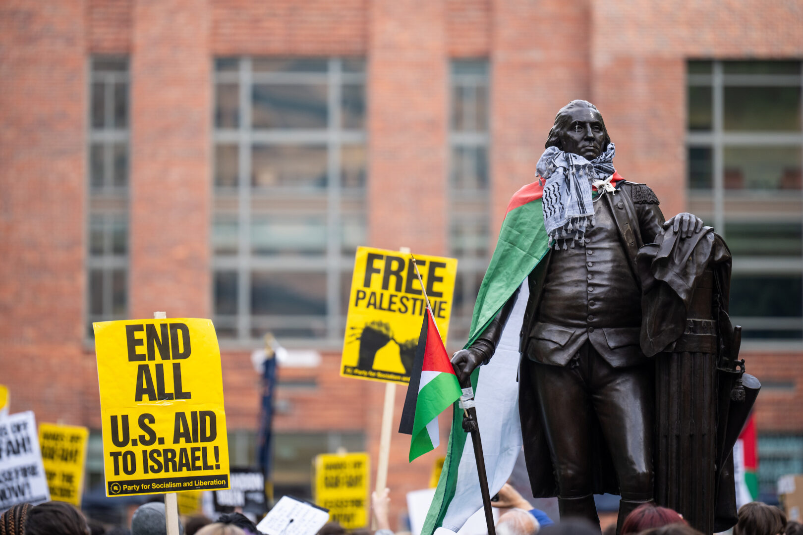 A Palestinian flag is wrapped around a statue of George Washington amid a George Washington University encampment protest on April 25. As campus protests unfold around the country, lawmakers in Congress are weighing in. 