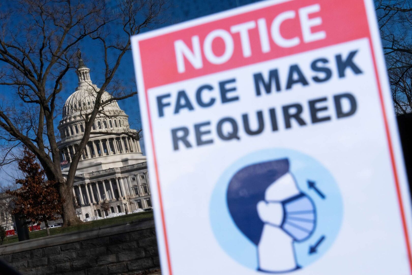 A sign reminding riders to wear a face mask to prevent the spread of COVID-19 appears on a bus outside the Capitol in January. The CDC on Thursday eased guidelines for those exposed to the virus. 