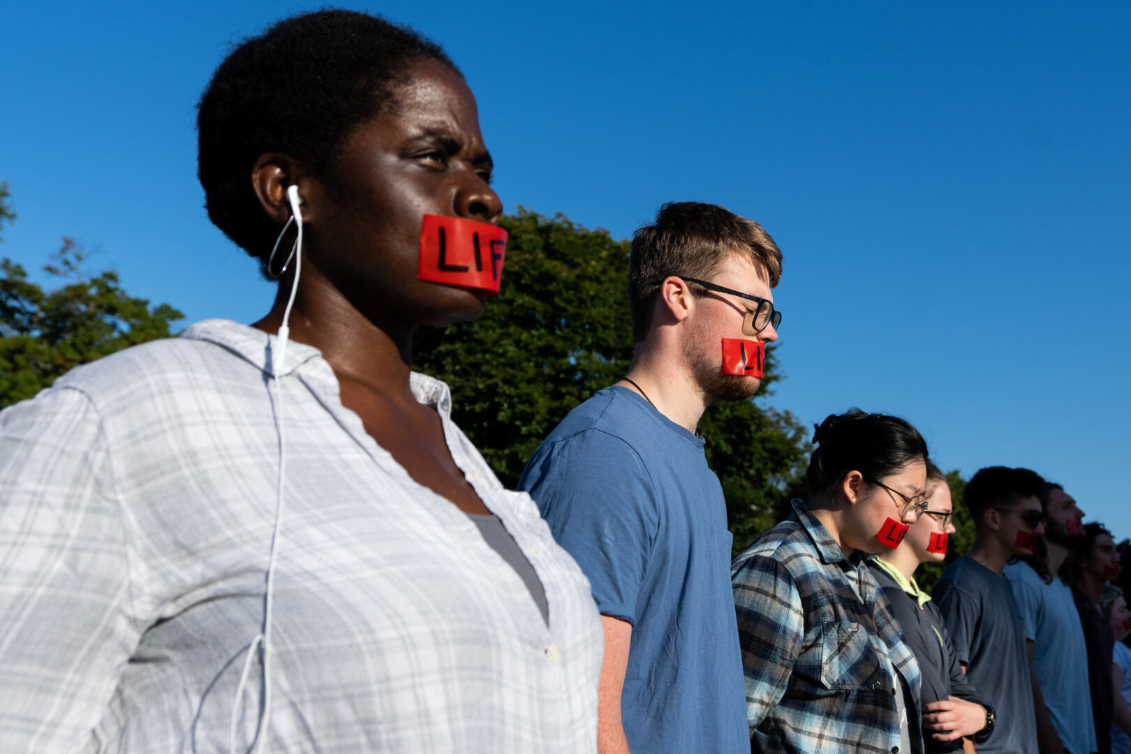 A dozen people with the Bound4LIFE group stand in front of the U.S. Supreme Court building with red tape over their mouths. While 18 U.S. states have essentially banned abortion for pregnant people facing a mental health crisis, Ireland, which had one of the strictest abortion laws in the European Union until 2018, has protected the right to seek an abortion because of the risk of suicide since 1992.