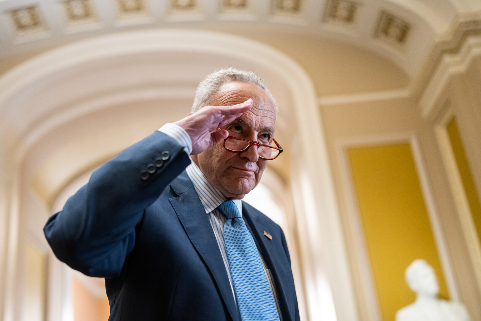 Senate Majority Leader Charles E. Schumer, D-N.Y., jokingly salutes an aide during a news conference in the Capitol on Tuesday.