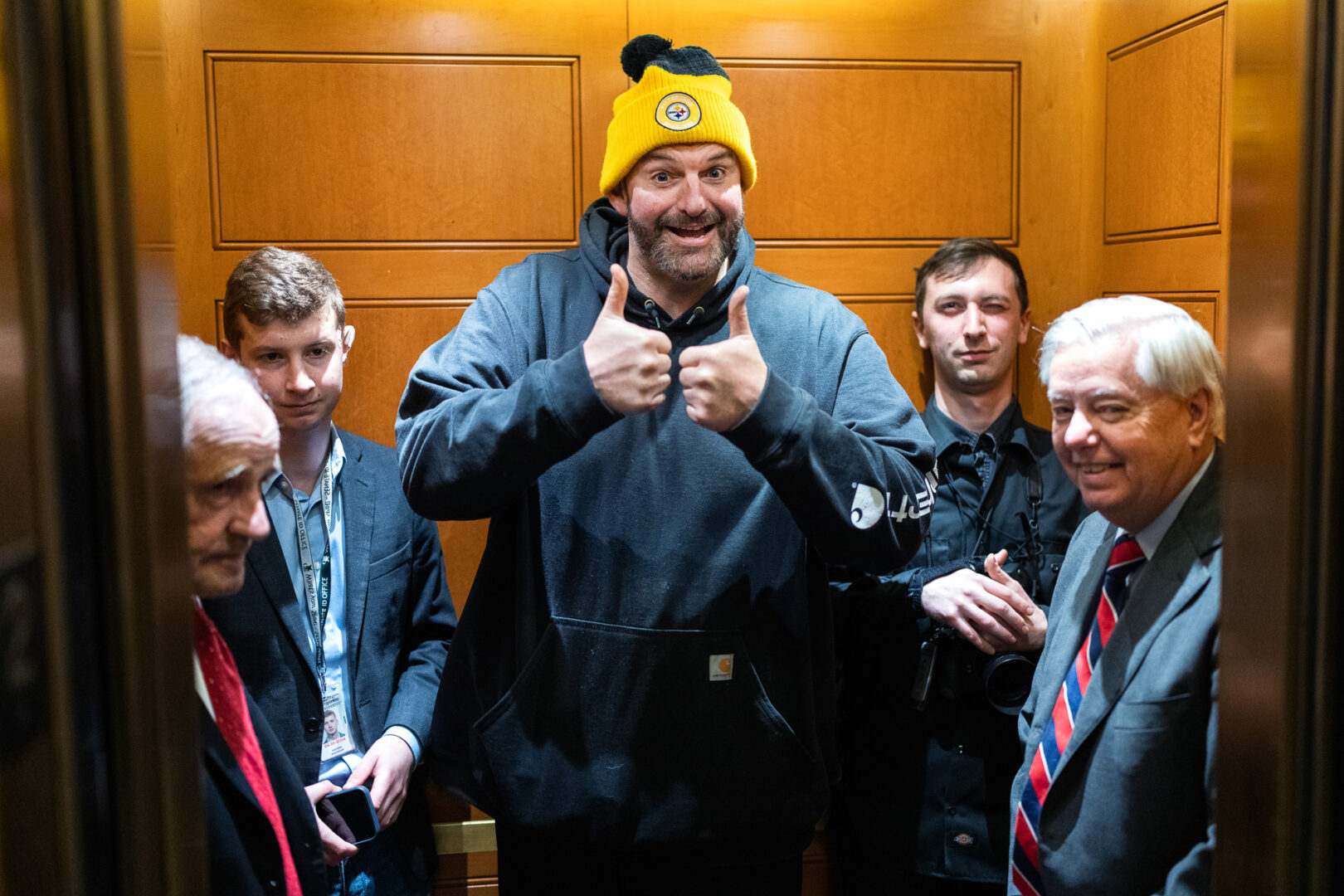 Democratic Sen. John Fetterman of Pennsylvania, center, gives a thumbs up in the Capitol on Tuesday as he rides an elevator with GOP Sens. Jim Risch of Idaho, left, Lindsey Graham of South Carolina, right.