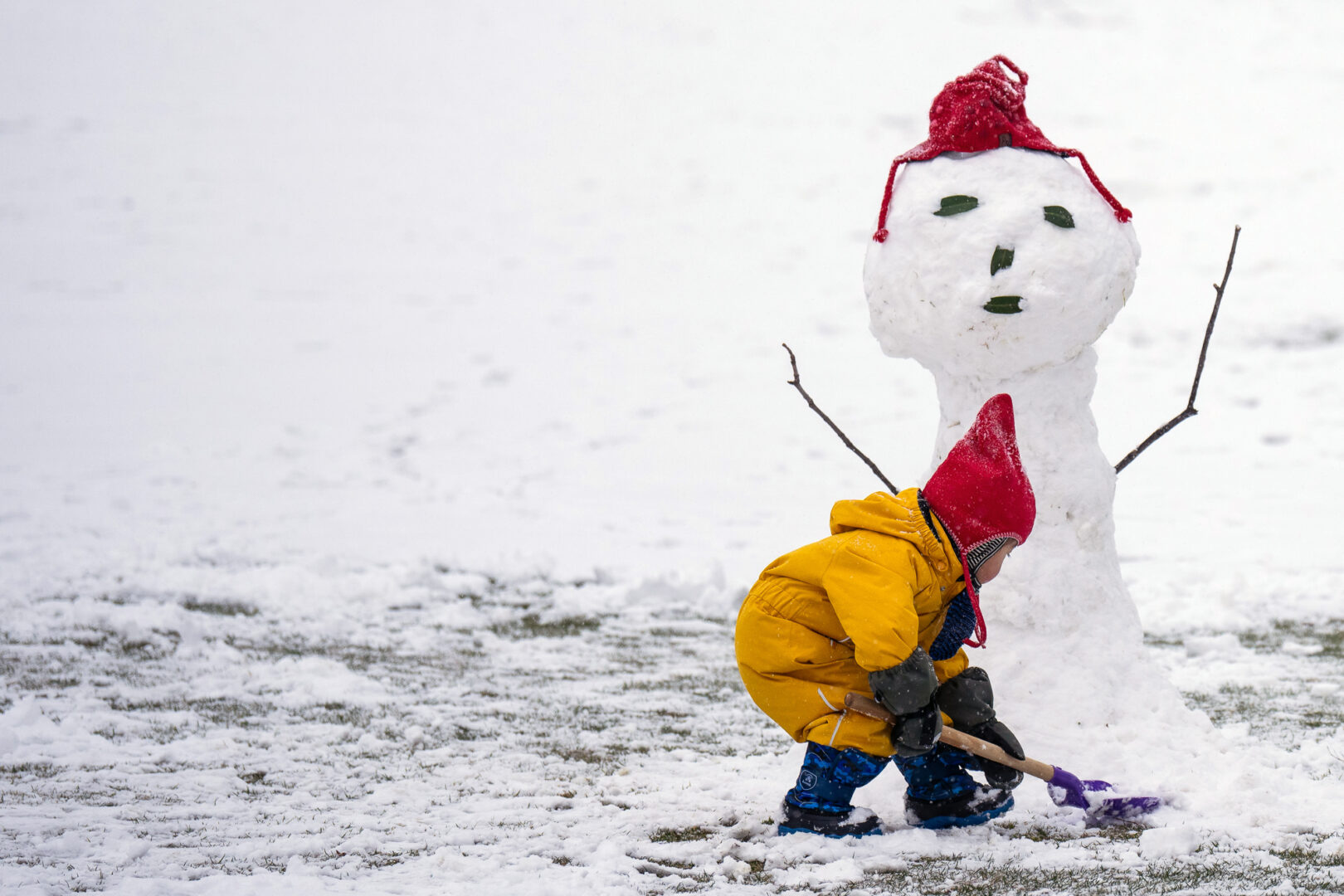 A child helps build a snowman on the West Front of the U.S. Capitol as snow falls in the Washington area on Monday. (Bill Clark/CQ Roll Call)