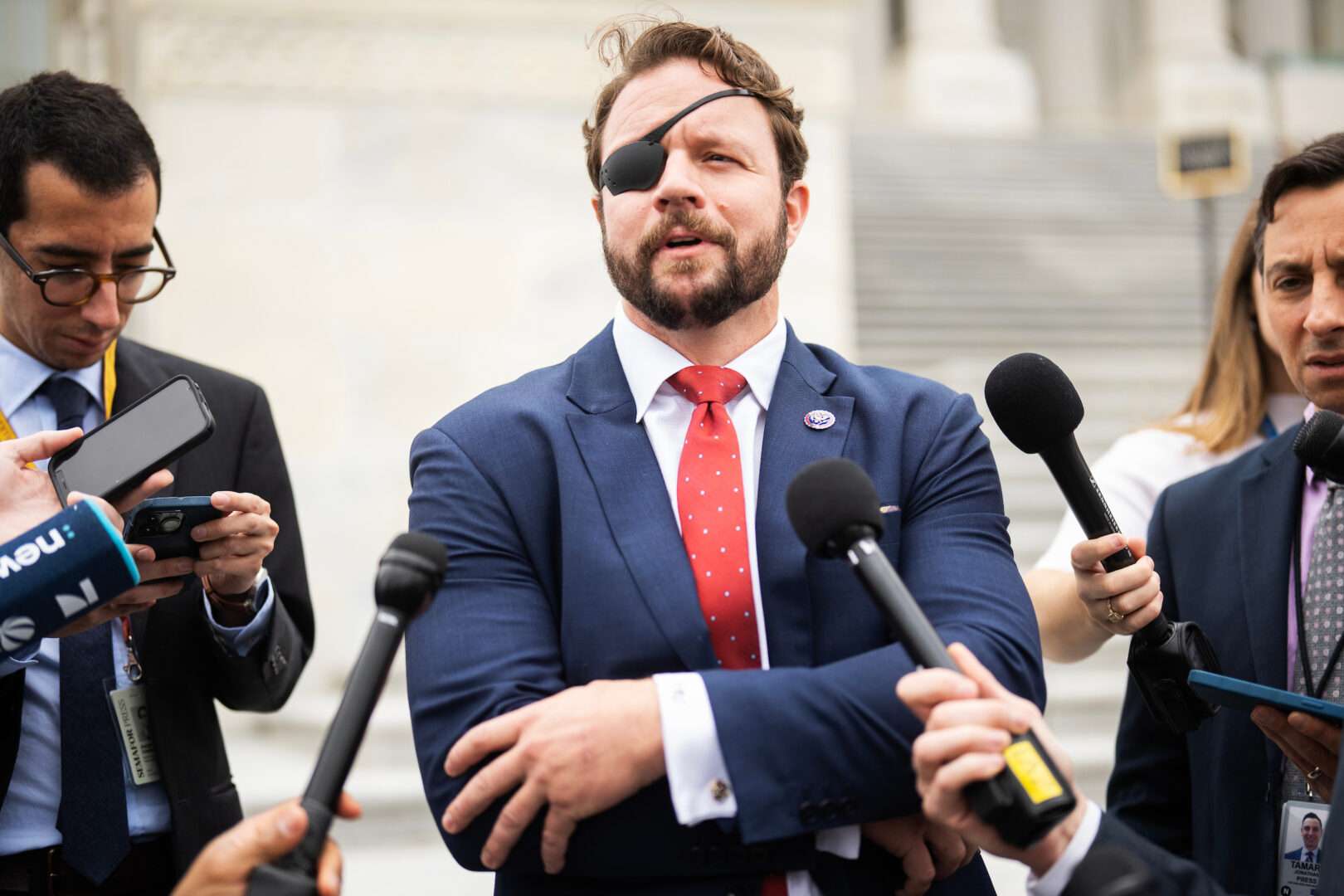 Texas Republican Rep. Daniel Crenshaw talks with reporters outside the Capitol. Crenshaw led  a legislative push to tie pediatric physician training to gender-affirming care bans but now acknowledges the House needs “to get a bill to the floor.”