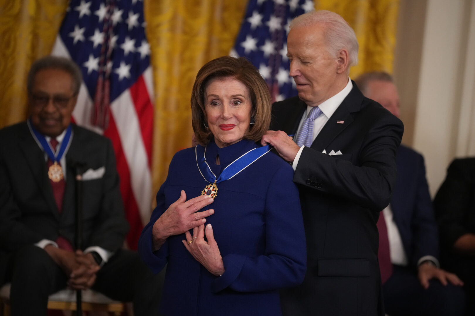 President Joe Biden pins a Presidential Medal of Freedom around the neck of former Speaker Nancy Pelosi, D-Calif., on Friday at the White House.