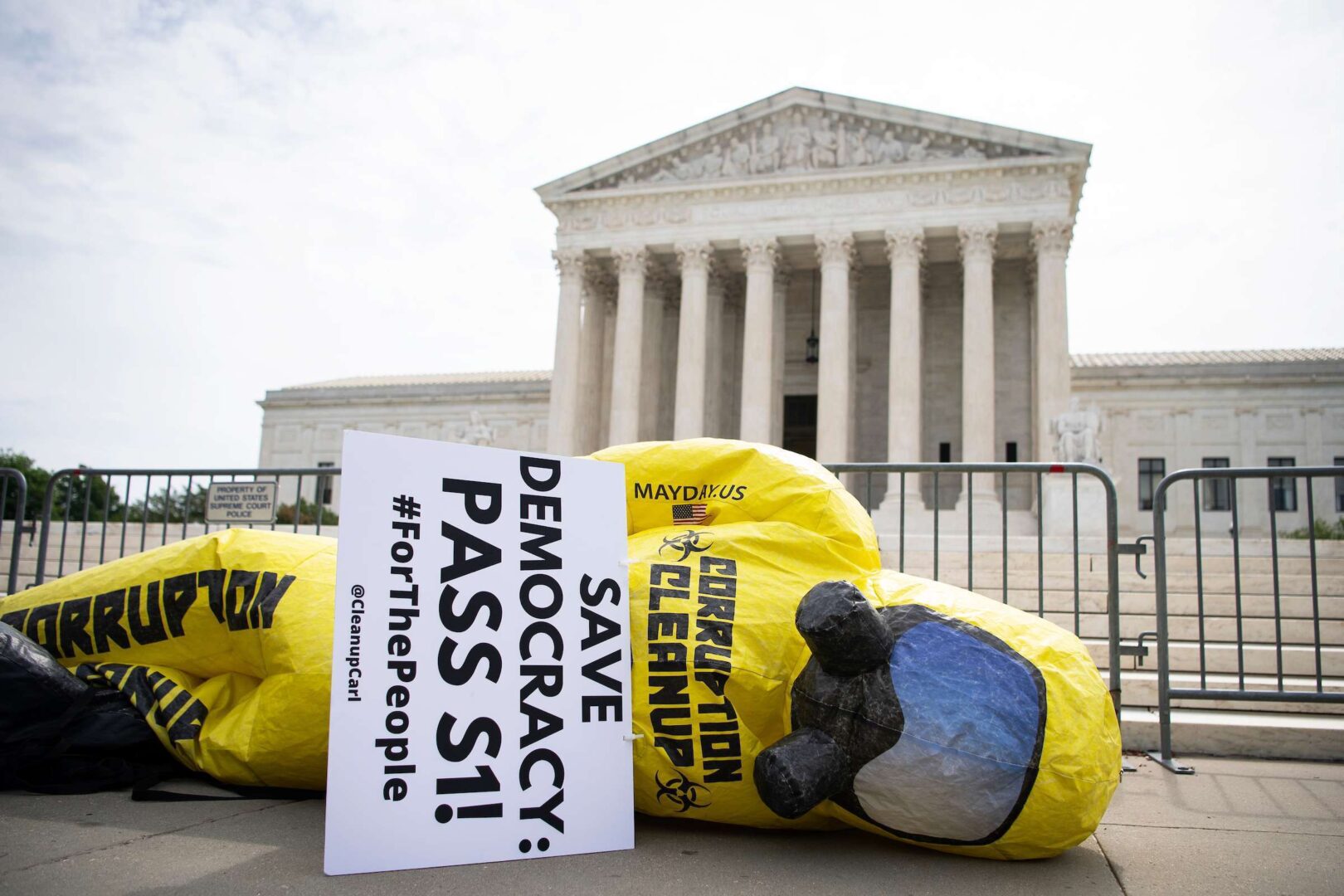 A blowup figure lies on the ground outside the Supreme Court on Wednesday as the Declaration for American Democracy coalition hosts a rally calling on the Senate to pass the S 1 elections overhaul. 