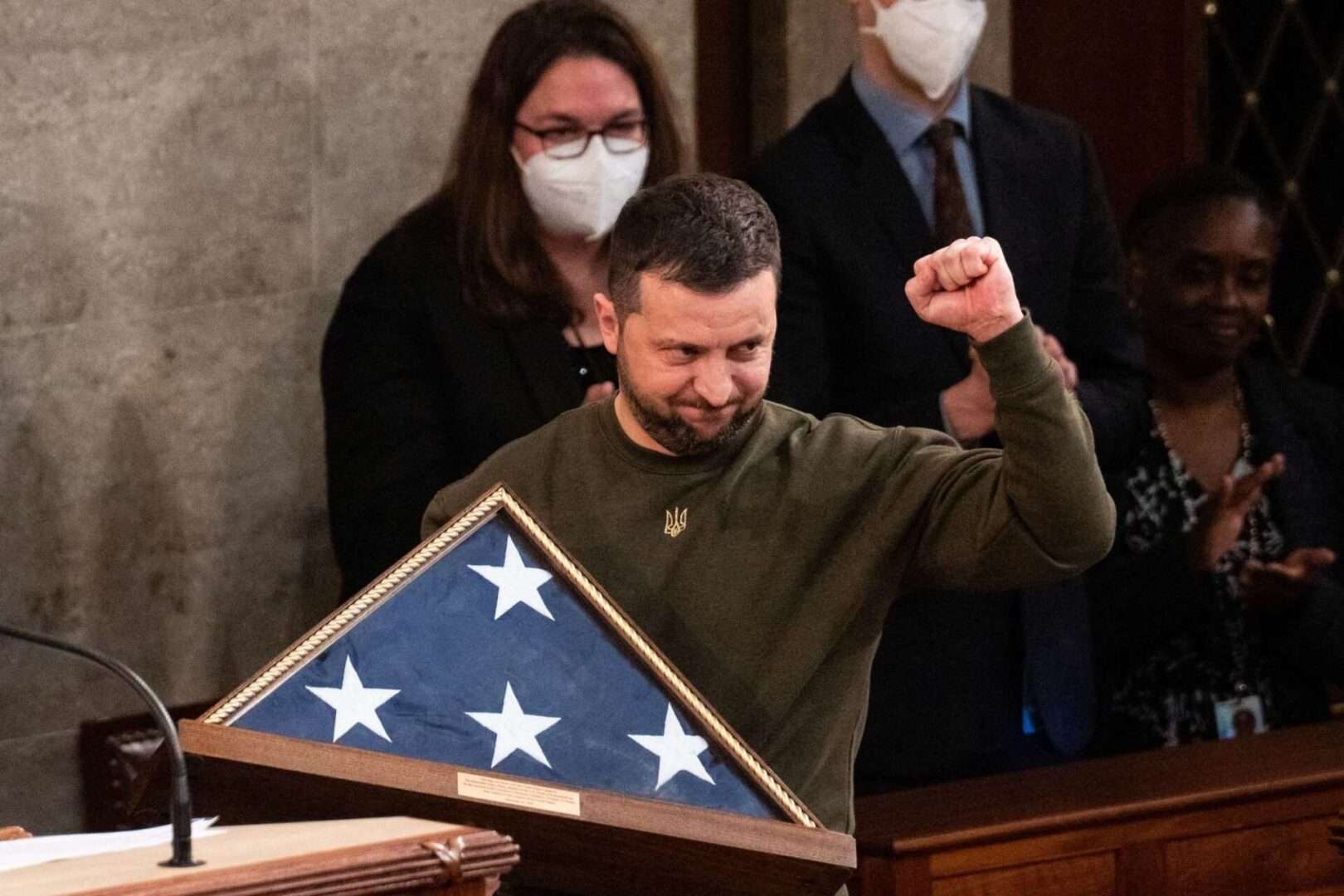 Ukrainian President Volodymyr Zelenskyy holds an American flag gifted to him by then-Speaker Nancy Pelosi, D-Calif., after he addressed a joint meeting of Congress on Dec. 21, 2022.